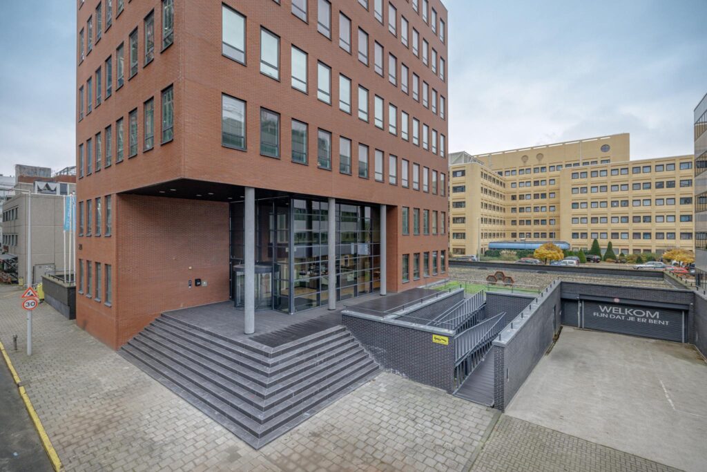 Entrance of a modern office building on Hiridostraat with adjacent underground parking access.